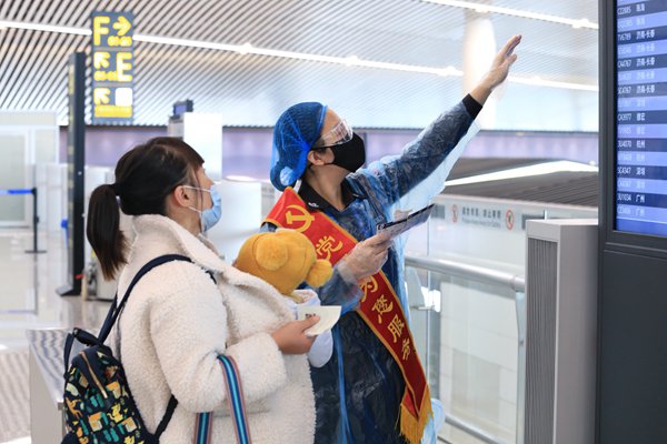 疫情期間，重慶機場安全檢查站黨員為旅客提供服務。重慶機場集團供圖
