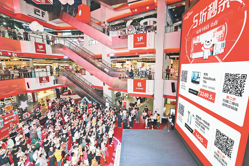 6月18日零時，寸灘京東超級體驗店，消費者聚集在大屏幕前，齊舉手機掃描二維碼，參與京東618電器整點5折秒殺活動。陸綱 攝/視覺重慶