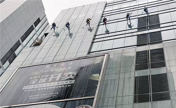 “蜘蛛人”正在從上至下清洗大樓玻璃外墻。