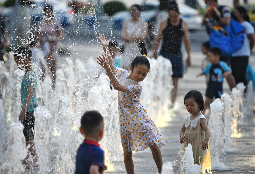 重慶連晴高溫，小朋友在南濱路噴泉下戲水玩耍享受清涼。郭旭攝