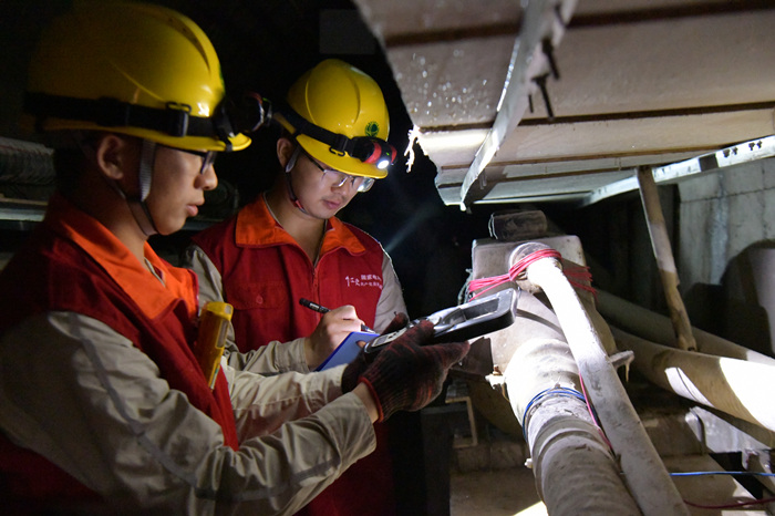 電力公司員工在解放碑地下環形電力隧道里巡查。潘洪攝