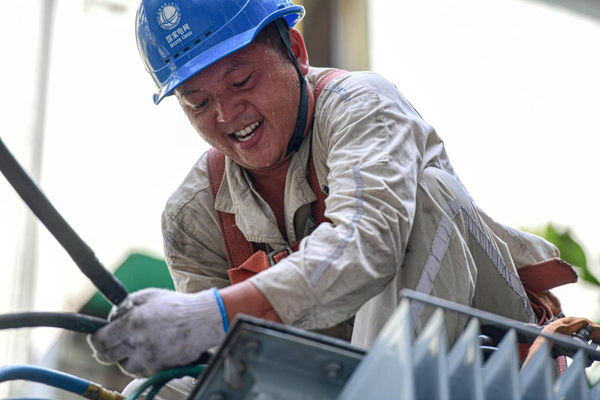 7月13日，國網合川供電公司員工在10千伏皂蟠線公園路中人2號臺區搶險配變。秦曉東攝