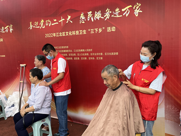 青年志愿者為老人公益剪發、按摩。蔣海濤攝