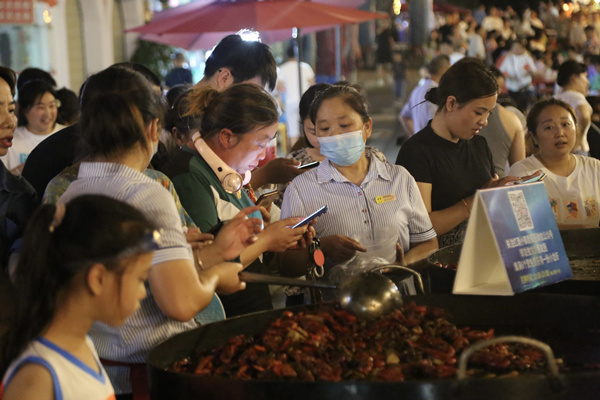 游客品嘗海鮮燒烤。楊孝永攝