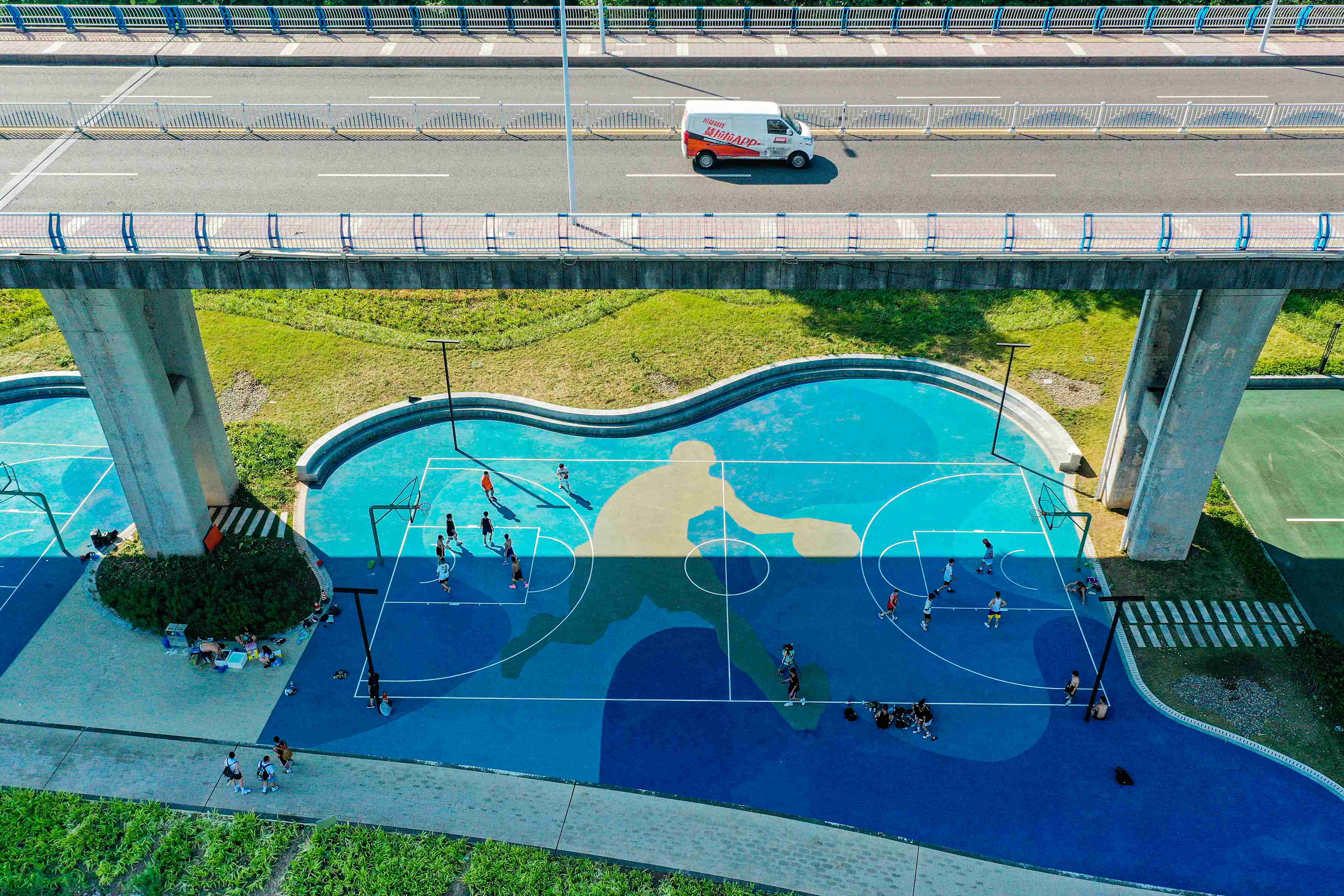 在渝中區黃沙溪大橋下，市民在長江邊的籃球場打球。何超攝