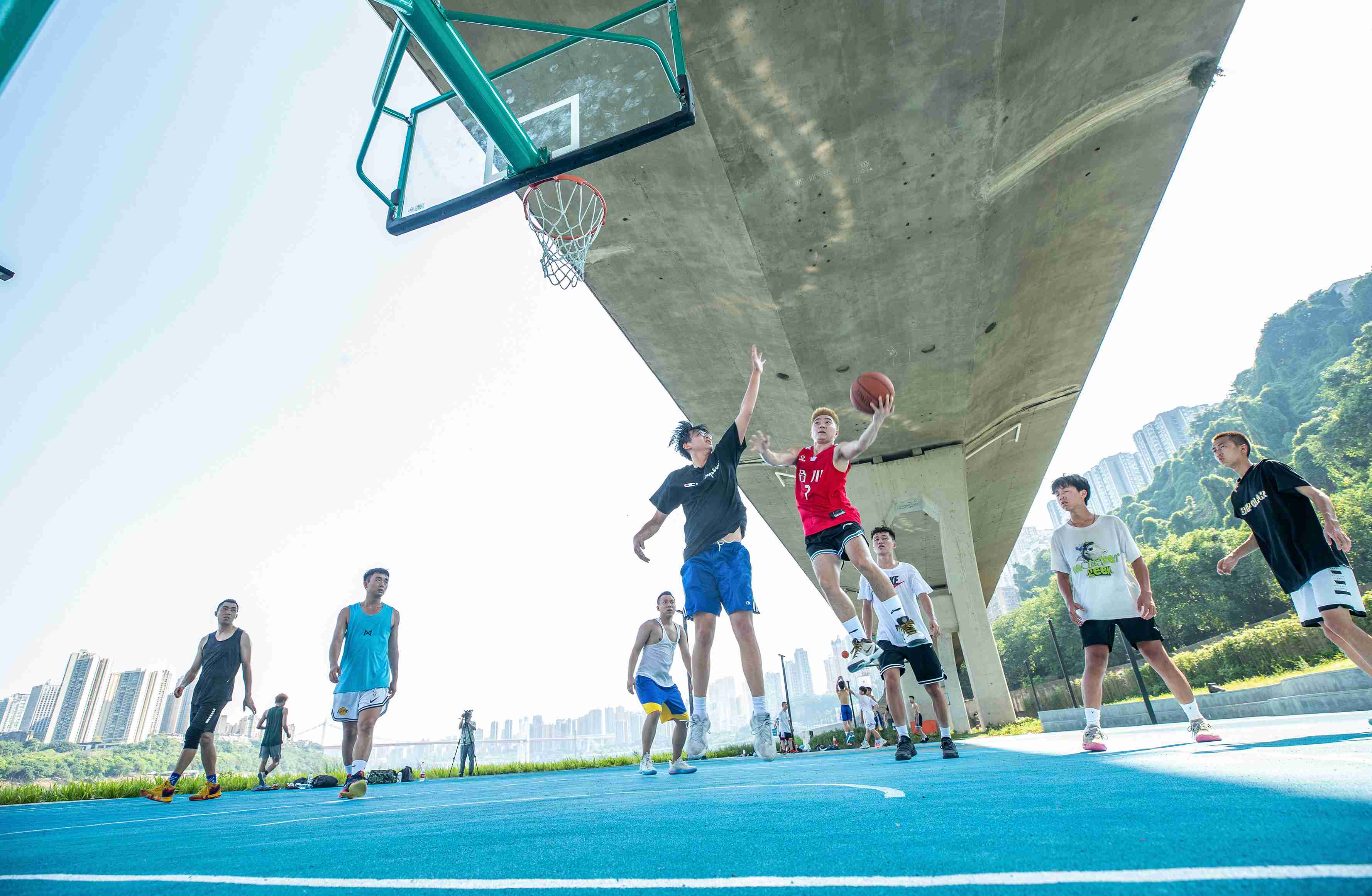 在渝中區黃沙溪大橋下，市民在長江邊的籃球場打球。何超攝