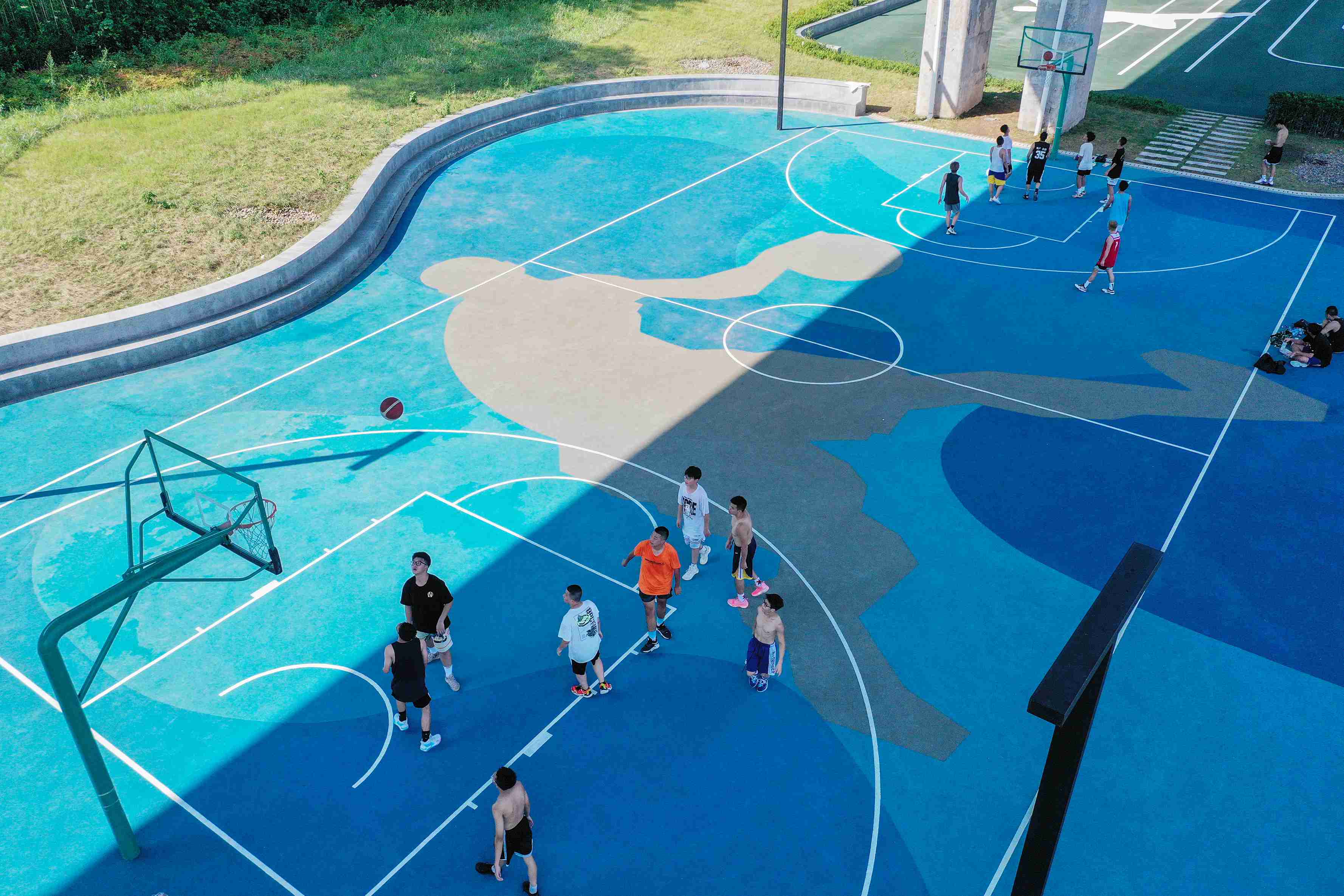 在渝中區黃沙溪大橋下，市民在長江邊的籃球場打球。何超攝