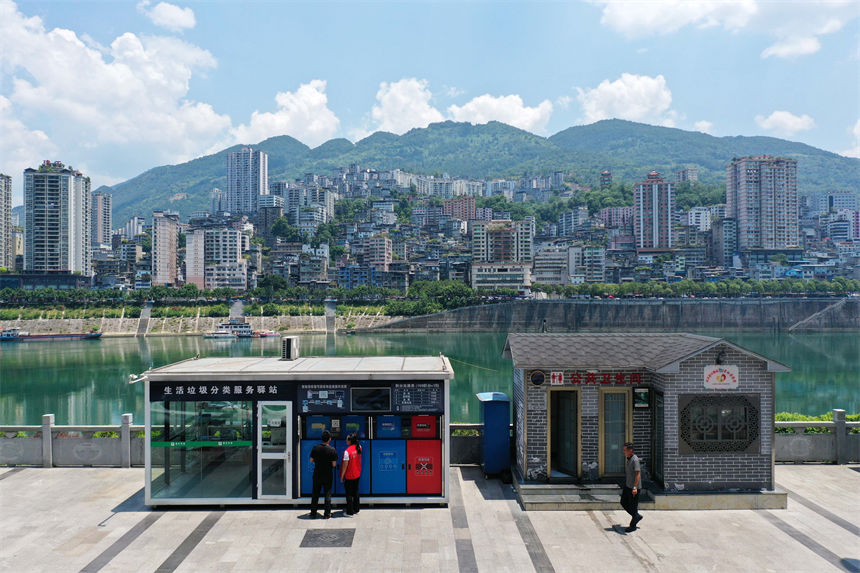 在彭水苗族土家族自治縣南濱路生活垃圾分類服務驛站，管理員給市民講解垃圾分類知識。楊敏攝