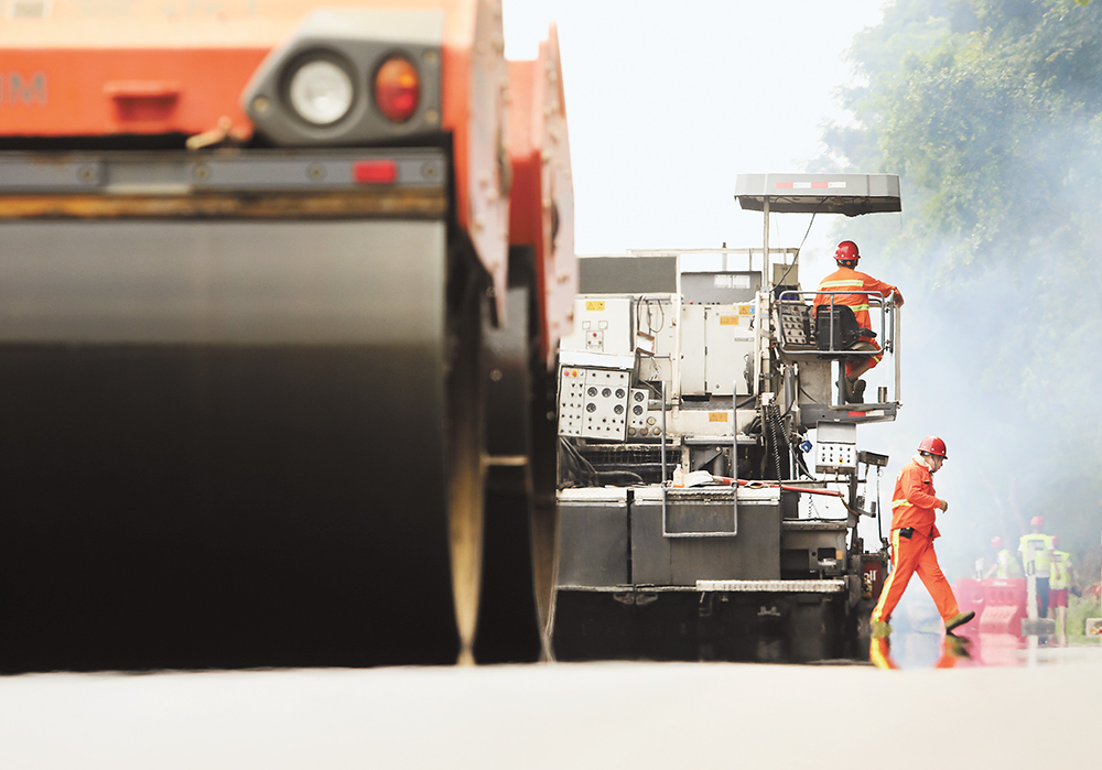 近日，繞城高速青木關段，重慶高速集團通力公司的養護工人，冒著高溫對路面進行翻新。記者 羅斌 攝視覺重