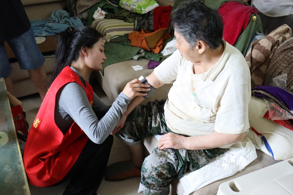 志愿者為老人測量血壓。李雪攝