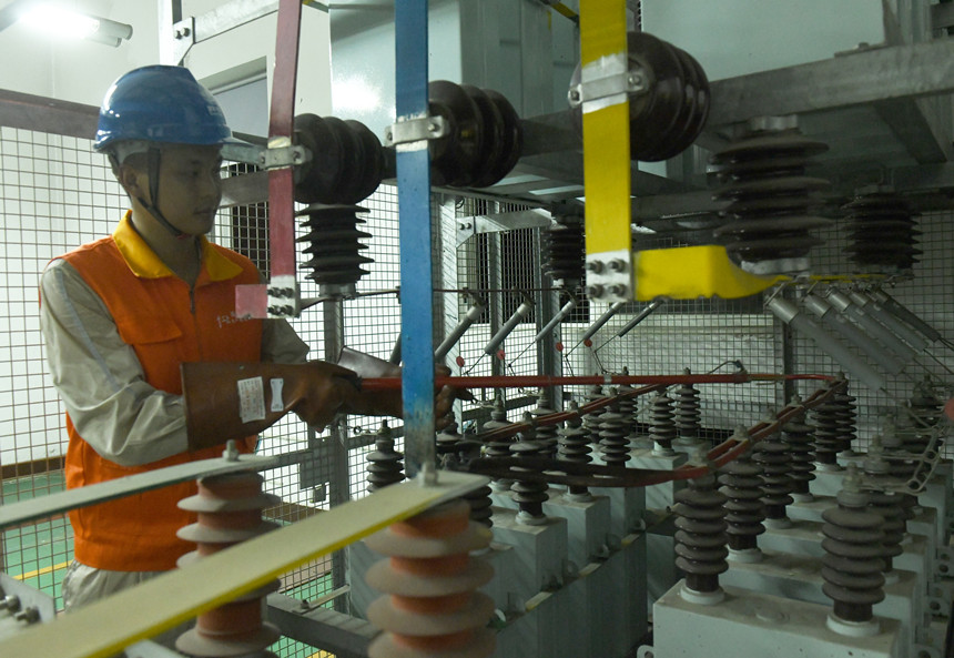 8月10日晚，國家電網紅巖（璧山運檢）共產黨員服務隊隊員在110千伏大路變電站檢修4號電容器。周毅攝