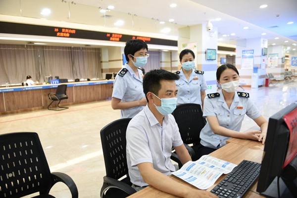 稅務特約監督員在辦稅服務廳自助辦稅區體驗電子稅務局“十七稅”合并申報、發票領用等功能。陳紅梅攝