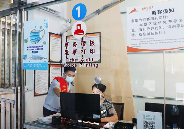 在“816工程”景區售票窗口，“心玲小家”工作室成員正輔導工作人員升級開票軟件。吳楠攝