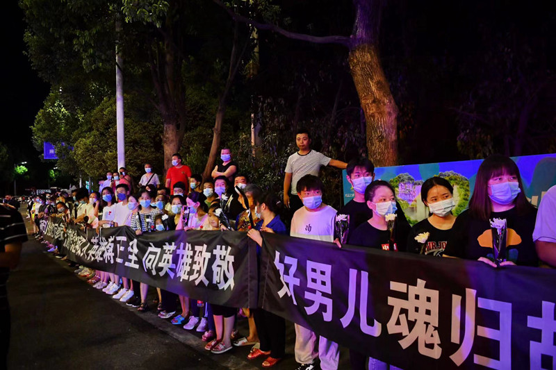 當地群眾自發迎接英雄回家。賀奎攝