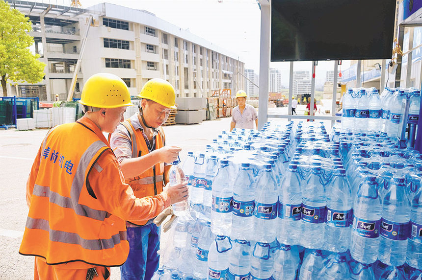 8月15日，南岸區廣陽灣智創生態城通江新城中學項目現場，施工人員在項目部補水點領取瓶裝飲用水。特約攝影 郭旭/視覺重慶