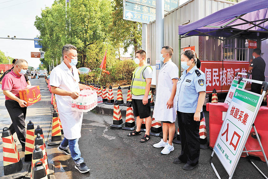 8月16日，成渝高速公路大足郵亭站核酸檢測點，郵亭鎮工作人員送來防暑降溫藥品、飲料等，保護核酸檢測點工作人員身心健康。通訊員 譚顯全 攝/視覺重慶