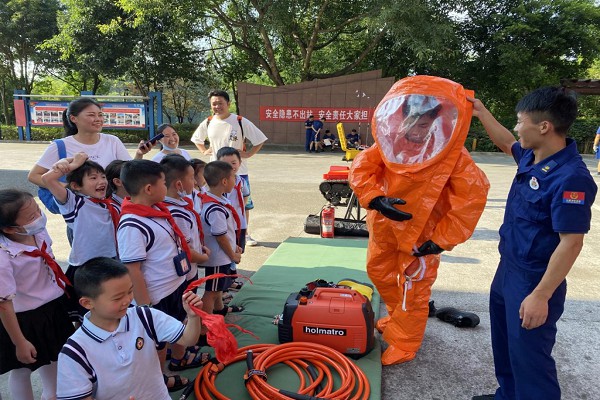 消防員向師生演示消防服的穿戴方法。渝北區消防救援支隊供圖