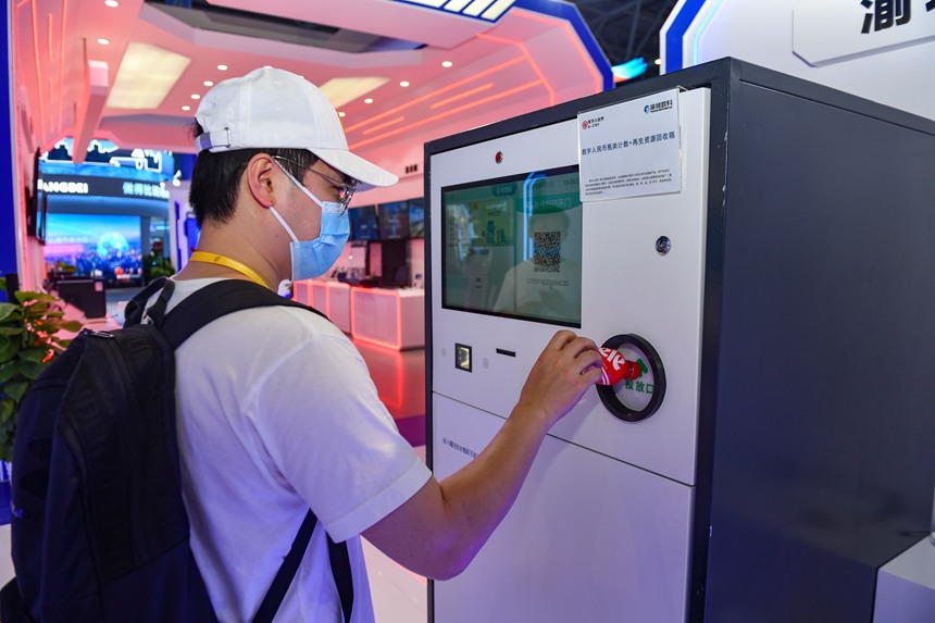 2022智博會重慶渝中區展廳，數字人民幣+再生資源回收項目展示，把喝完的水瓶投入回收箱，即可返還數字人民幣。鄒樂攝