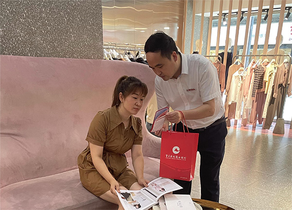 重慶農商行武隆支行客戶經理向周女士介紹創業擔保貸款相關政策。重慶農商行供圖