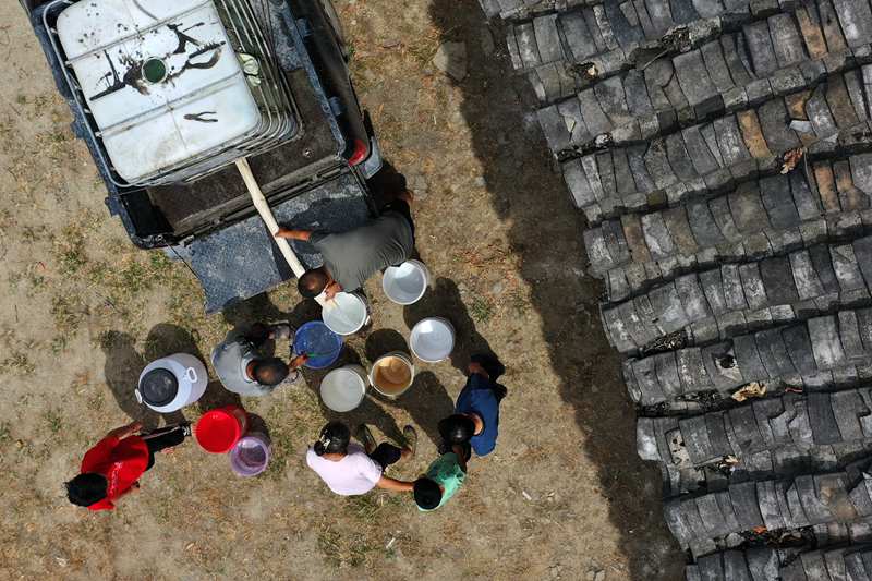 村民在送水車前接水。楊敏攝
