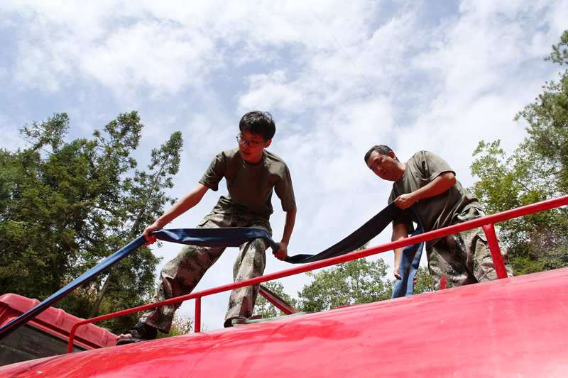 專班人員在新花村新找的水源點給送水車裝水。楊敏攝
