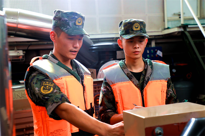 老兵為戰友講解船艇機器參數。錢云星攝