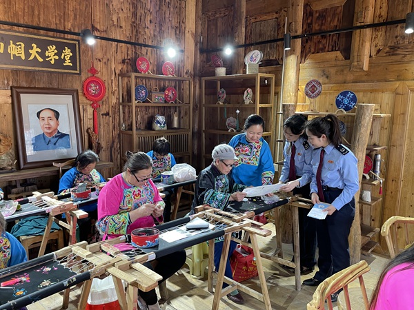 酉陽縣稅務局工作人員走進酉陽縣子月苗族文化傳播有限責任公司，向苗繡職工講解組合式稅費支持政策。 邱冰攝