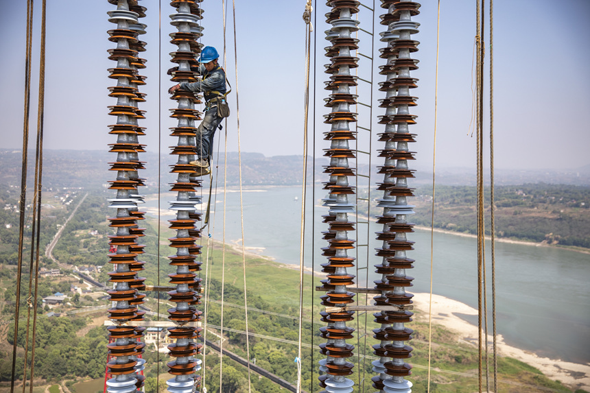 9月13日，在重慶市江津區白浙線長江大跨越施工現場，施工人員正在攀爬絕緣子串。黃偉攝