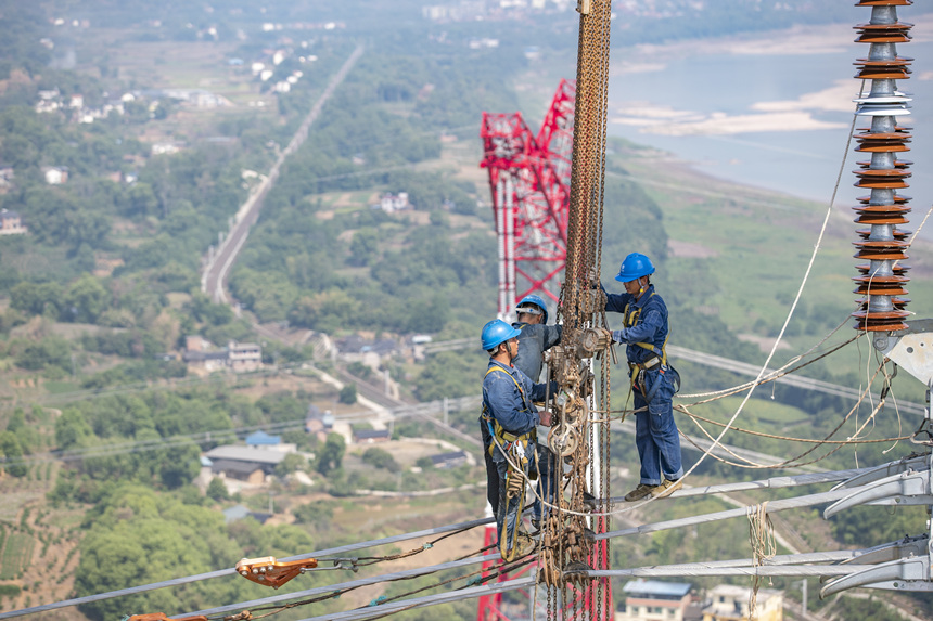 9月13日，在重慶市江津區白浙線長江大跨越施工現場，施工人員正在進行導線附件安裝。黃偉攝