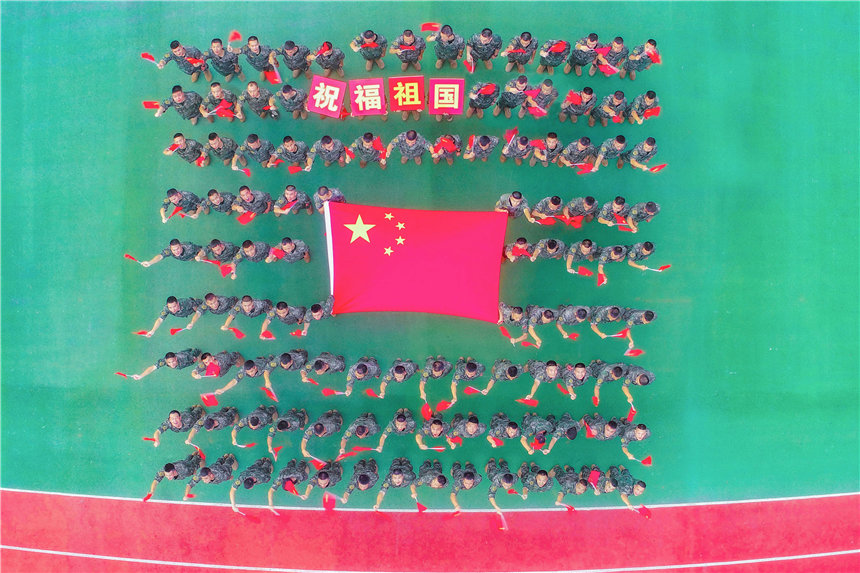 武警官兵與國旗合影，祝福祖國。李東攝