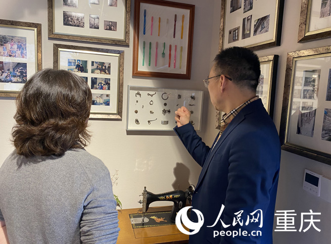  丁勝為市民介紹為紀念父母工作經歷制作的裝飾畫。人民網 劉祎攝