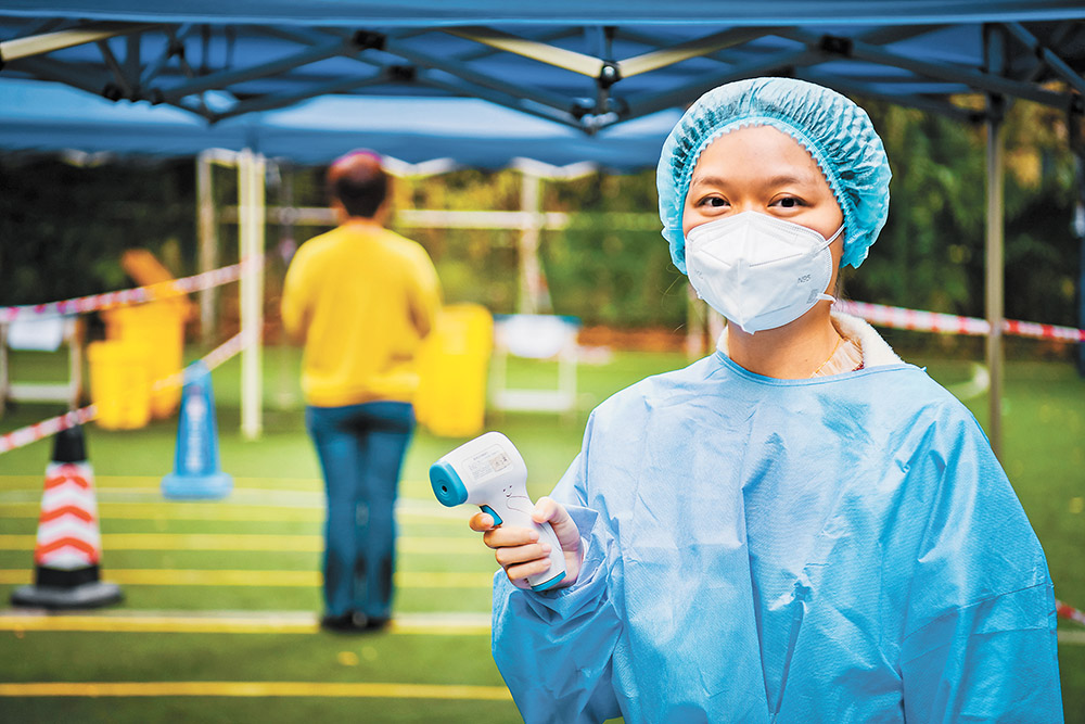 11月17日，綦江區文龍街道半山國際小區檢測點，“95后”志愿者劉柳吟為前來核酸采樣的居民測量體溫。特約攝影 陳星宇 視覺重慶