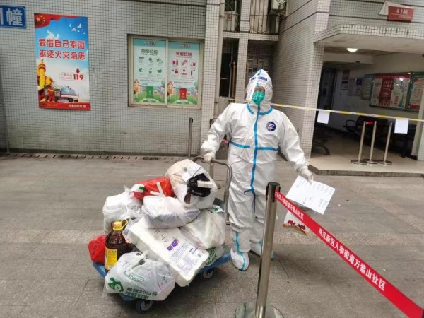 兩江新區志愿者為居民們搬運物質。兩江新區人和街道萬紫山社區供圖