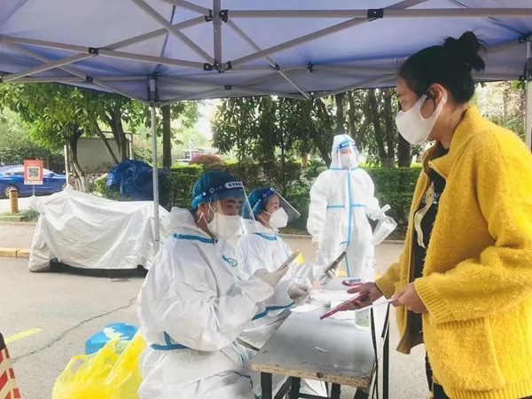 重慶市地產集團黨員冉淵（左一）協助社區進行核酸檢測信息錄入工作。重慶市地產集團供圖