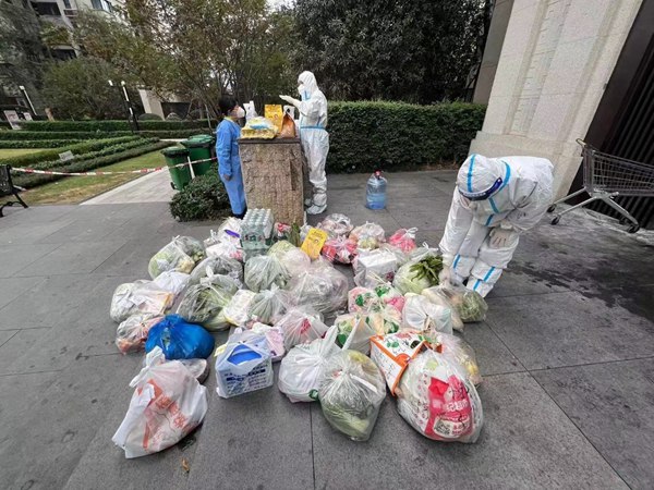 重慶銀行兩江分行黨員楊晶（右）為居民提供無接觸上門配送蔬菜、藥品等服務。重慶銀行供圖