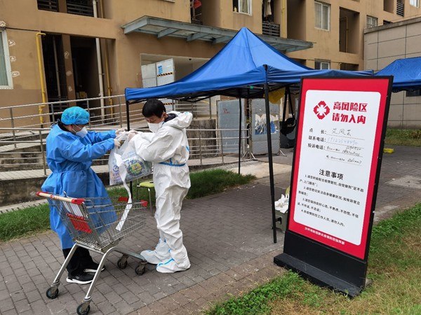 重慶交運集團黨員羅開祿協助當地社區到高風險區樓棟為住戶送生活物資。重慶交運集團供圖