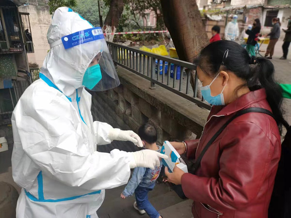 重慶燃氣集團江北分公司黨員龍沙向居民講解抗原檢測試劑的操作方法。馬久虎攝