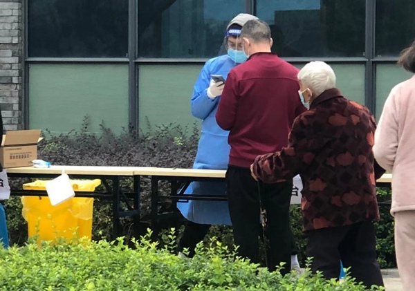 四聯集團黨員任國偉協助做好核酸檢測登記工作。四聯集團供圖