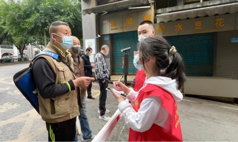 “00后”志愿者秦榕浚一一記下附近居民所需的蔬菜。蔣歡攝