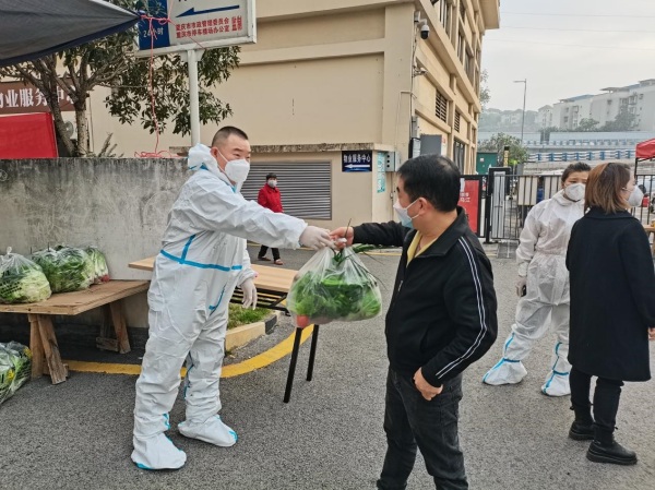 物業工作人員向居民發放蔬菜包?？蹬d路社區供圖
