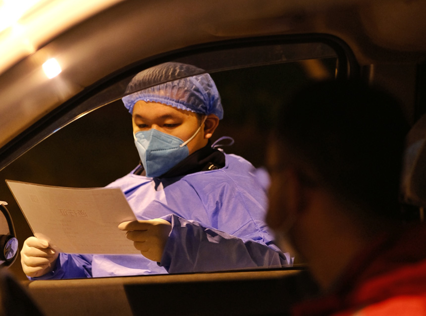 經開區通盛工業園區，經開區志愿者在園區路口檢查通行證，保障園區安全生產。郭旭 攝