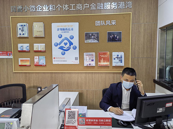 重慶農商行江津分行客戶經理王勝電話指導客戶通過“云簽約”辦理貸款手續。重慶農商行供圖