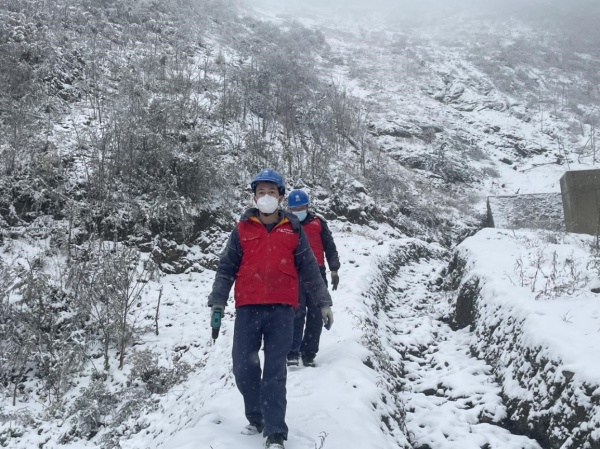 11月30日，國網城口供電公司員工踩著積雪巡視檢查10千伏廟羅線。王成躍攝