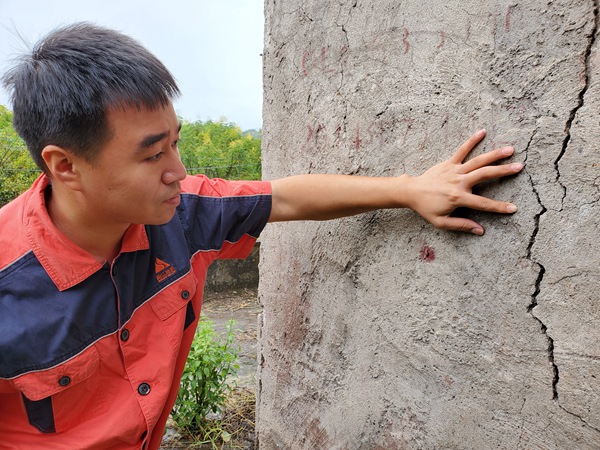 《調查房屋裂縫》。10月17日，南江地質隊駐守地質隊員陳昊在開州區白鶴街道棕陡坪滑坡調查居民房屋裂縫。彭向東攝