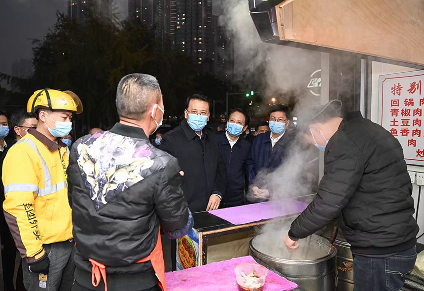 12月12日下午，在解放碑中央商務區，市委書記袁家軍同面館老板交流。記者 蘇思 攝/視覺重慶