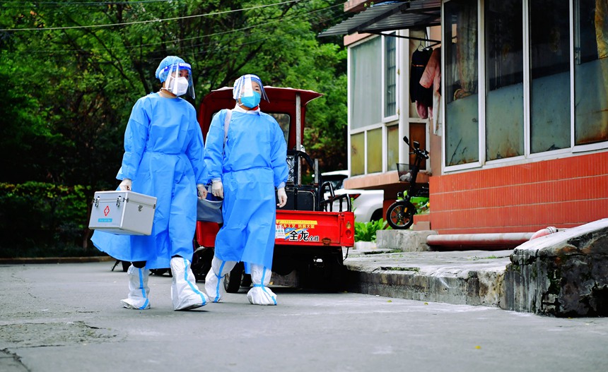 社區工作人員和醫護人員在轄區宣傳疫苗接種。周舸攝