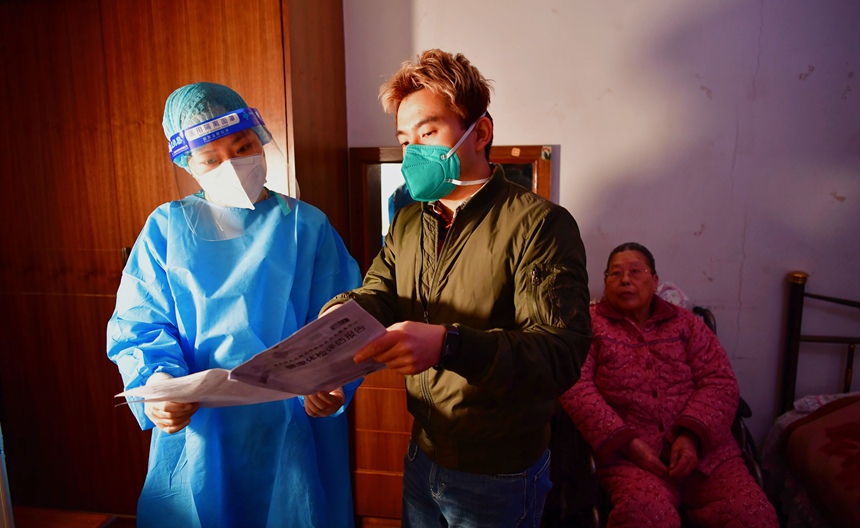 社區工作人員和醫護人員在轄區宣傳疫苗接種。周舸攝