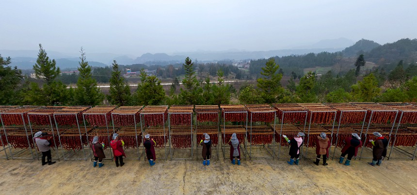 村民在寒風中忙晾曬。?冉孟軍攝
