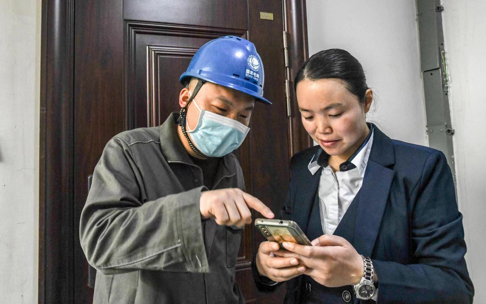 國網江津區供電公司員工向客戶講解二維碼的用途。王化全  攝