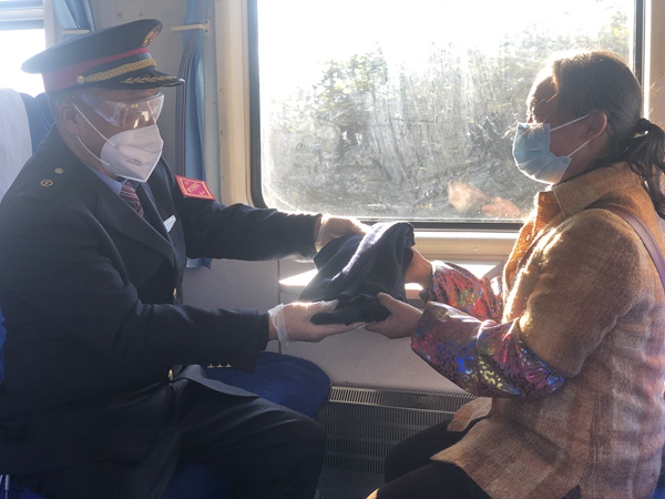 吳洪江帶給村民鄭啟梅丈夫的嶄新毛背心。張章攝